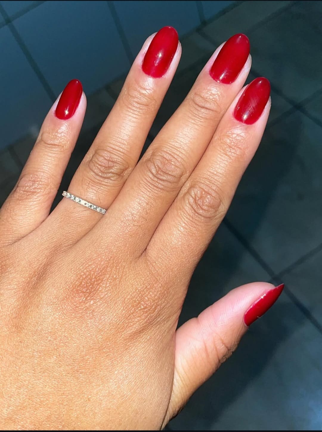 Unhas amendoadas com esmaltação vermelha feitas pela Emilly